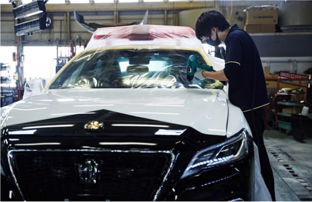 パトカーに保護フィルムを貼っている様子