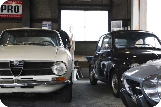 整備工場に並ぶ白と黒のクラシックカー