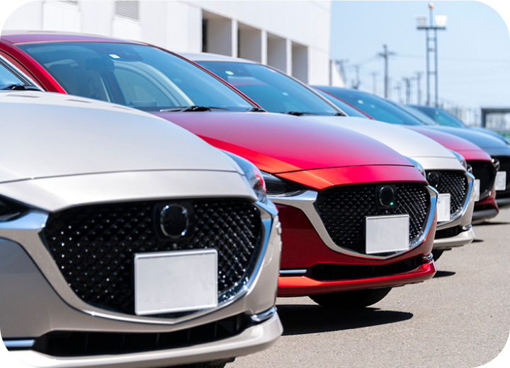 展示場に並ぶ新型車両、赤やシルバーのセダンが整列