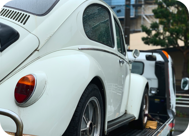 キャリアカーに積載された白いフォルクスワーゲン ビートル