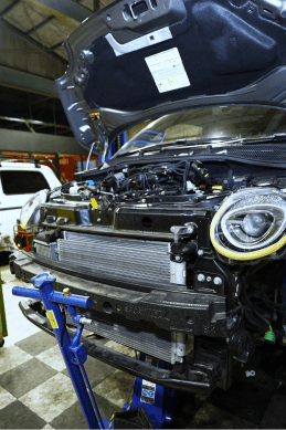 ボンネットが開いて整備せれている車の様子